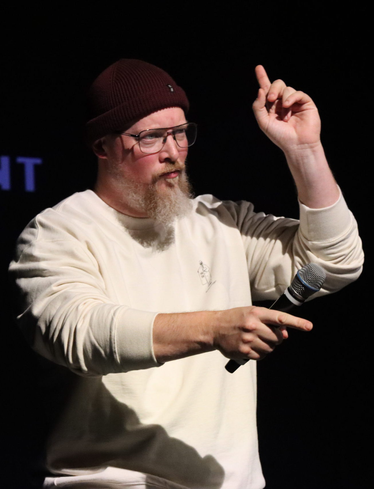 Jan mit Mütze und Brille macht Gesten mit den Fingern